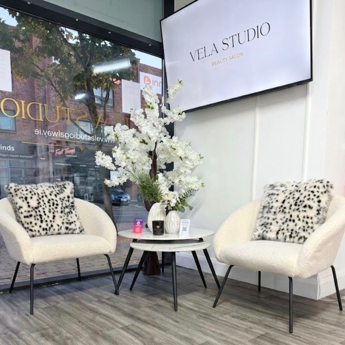 Vela Studio Galway reception area with two cream armchairs and a white blossom arrangement